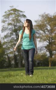 Teenage Girl Walking Through Summer Meadow