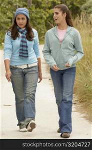 Teenage girl walking with a girl and talking