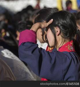 Teenage girl watching with shielding eyes, Paro, Bhutan