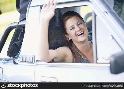 Teenage girl waving from car