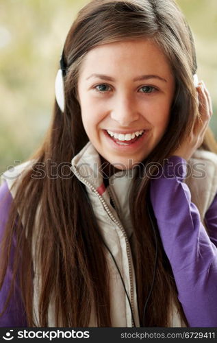 Teenage Girl Wearing Headphones And Listening To Music Wearing Winter Clothes