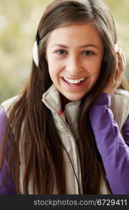 Teenage Girl Wearing Headphones And Listening To Music Wearing Winter Clothes