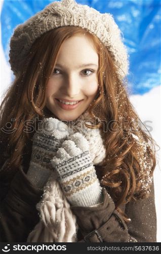Teenage Girl Wearing Warm Winter Clothes And Hat In Studio