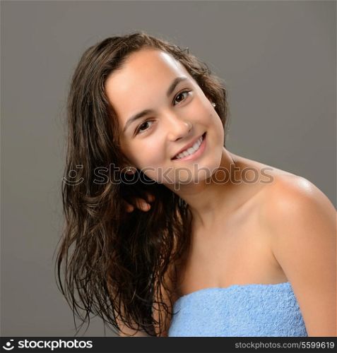Teenage girl wet hair care after shower on gray background