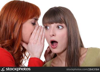 Teenage girl whispering in the ear