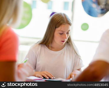 Teenage girl with books studying in library. Teenage girl with books