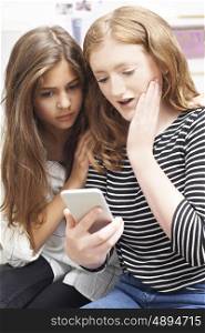 Teenage Girl With Friend Being Bullied By Text Message