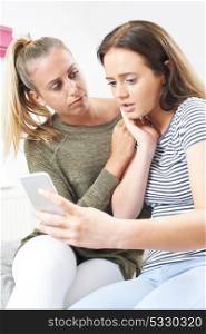 Teenage Girl With Friend Being Bullied By Text Message