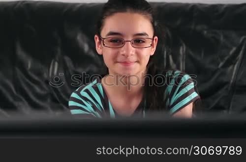 Teenage girl with glasses watching TV