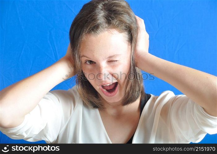 Teenage girl with her hands on her ears.
