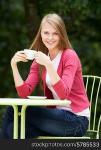 Teenage Girl With Hot Drink At Outdoor cafe