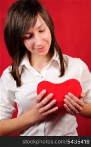 Teenage girl with red heart shape on red background
