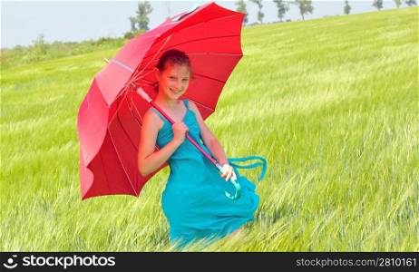 teenage girl with red umbrella in wheat field
