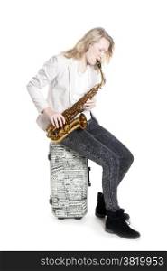 teenage girl with saxophone on suitcase with musical notes against white background in studio