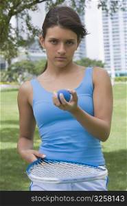 Teenage girl with tennis racket and a ball