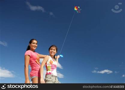 Teenage girls flying a kite