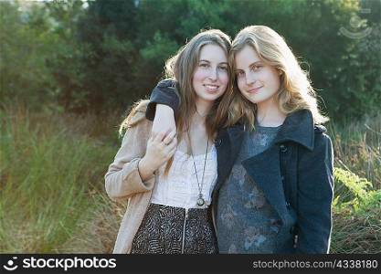 Teenage girls hugging outdoors