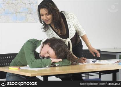 Teenage girls in a classroom, one of the girls has fallen asleep