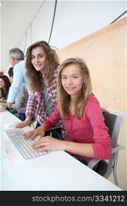 Teenage girls in front of desktop computer at school