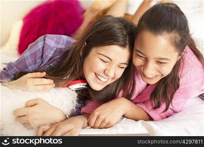 teenage girls laughing looking at laptop