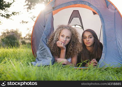 Teenage girls laying in tent at campsite