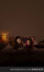 Teenage girls lying on the bed and using their mobile phones. 