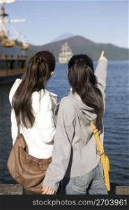 Teenage girls pointing at a ship
