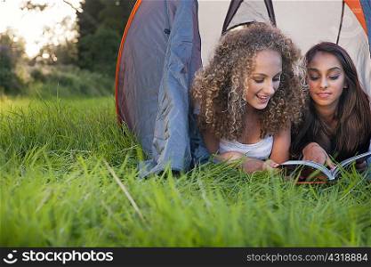 Teenage girls reading in tent