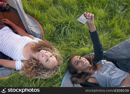 Teenage girls taking picture at campsite