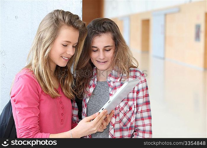 Teenage girls using electronic tablet at school