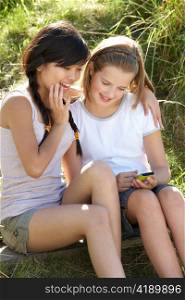Teenage girls using phone outdoors