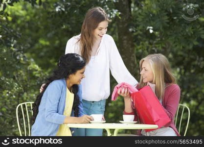 Teenage Girls With Shopping Bags At Outdoor cafe