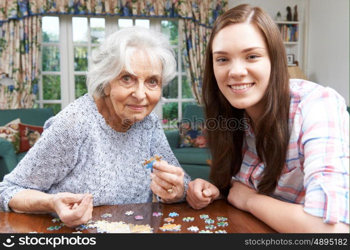 Teenage Granddaughter Doing Jigsaw Puzzle With Grandmother