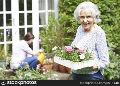 Teenage Granddaughter Helping Grandmother In Garden