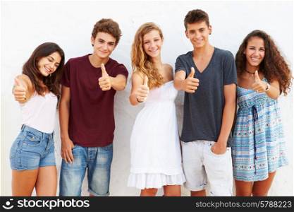 Teenage Group Leaning Against Wall Giving Thumbs Up