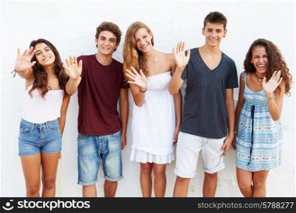 Teenage Group Leaning Against Wall Waving