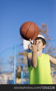 Teenage playing basketball on an outdoors court