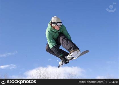 Teenage snowboarder jumping