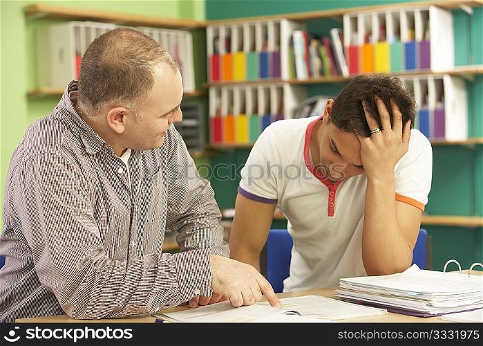 Teenage Student In Classroom With Tutor
