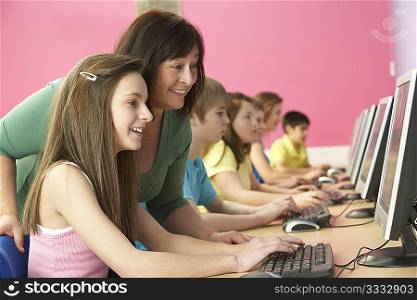 Teenage Students In IT Class Using Computers In Classroom With Tutor