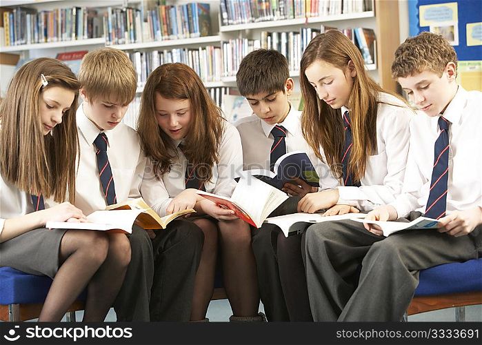 Teenage Students In Library Reading Books