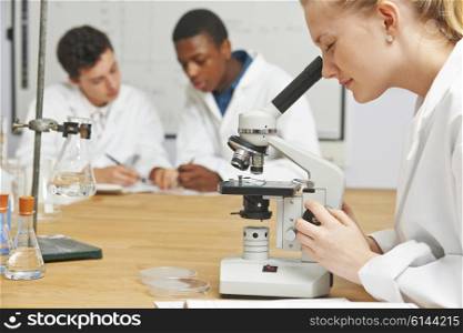 Teenage Students In Science Class Using Microscope