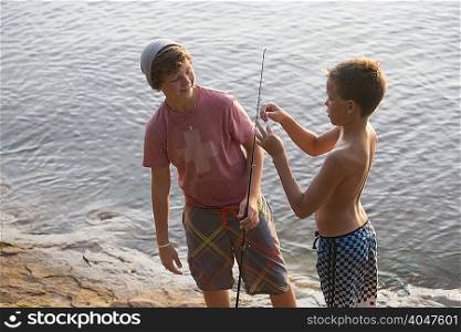 Teenage twin boys preparing fishing line, Lake Superior, Au Train Bay, Michigan, USA