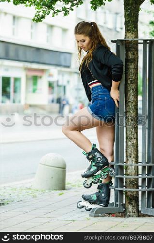 Teenage woman girl riding roller skates during summertime through city having great time.. Young woman riding roller skates