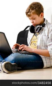 teenager boy is sitting with laptop at school