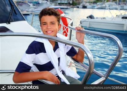 teenager boy sea marina summer vacation sitting in boat bow as sailor