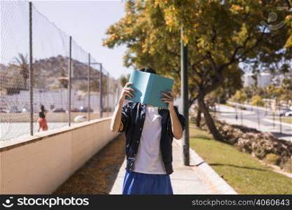 teenager closing face by book