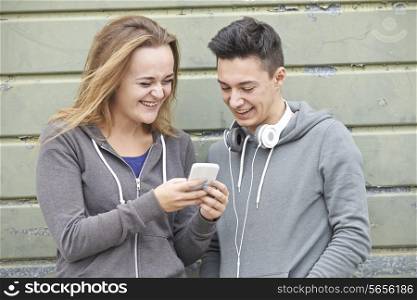Teenager Couple Sharing Text Message On Mobile Phone