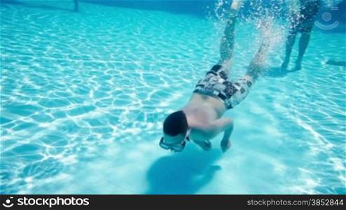 Teenager floats under water in pool