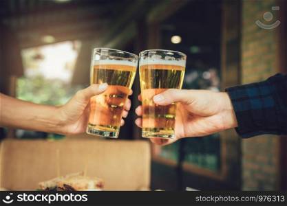 Teenager friends toasting and clinking with glass of beer.